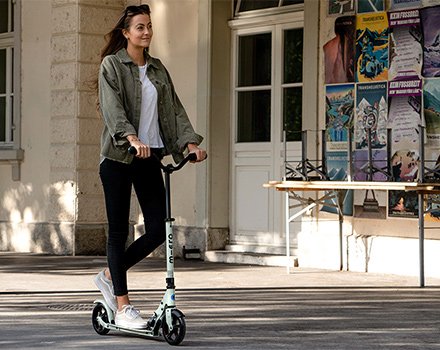 Woman riding kick scooter in street