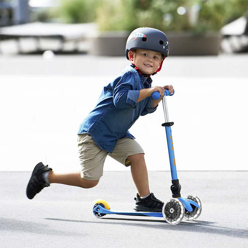Young boy riding on the Mini Micro Foldable LED scooter