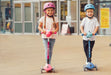 Kids riding the Globber Primo Lights foldable kick scooter